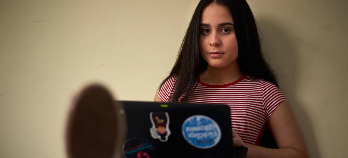 La estudiante refugiada venezolana Emily usa su computadora portátil en Quito, Ecuador.